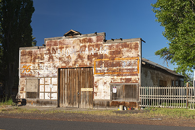 Dilapidated one-story building along a road.