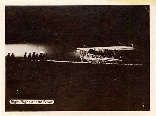 Dark night with front of airplane illuminated by artificial light.