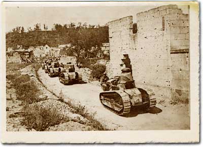 American tanks pass ruined buildings