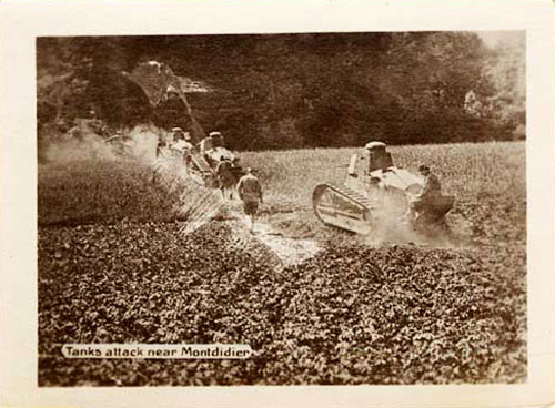 Tanks shown traversing field with wooded area ahead.