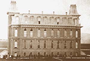 Four story, block-long building with a tower on each end and many windows. 