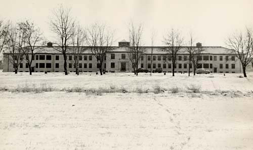 Oregon State Hosptial during winter shows snow covered ground and bare trees in front.