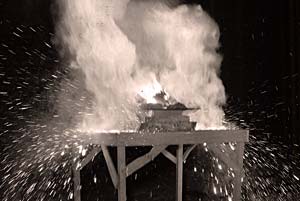 Photo of a thermite bomb in mid explosion shows smoke, sparks and flame.