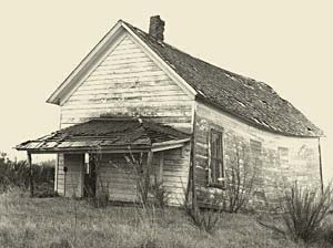 Run down, dirty, broken wooden shack of a building.