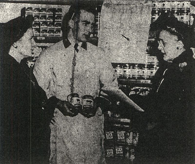 2 women talk with a man in a grocery store.