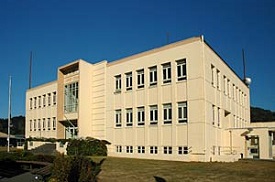 Three story square boxy building that is the courthouse for Curry County Oregon.