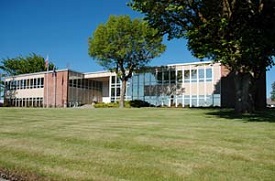 Gilliam county courthouse with wide lawn and trees in front.