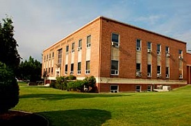 Harney county courthouse, a 3 story brick building with green lawn in front.