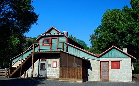 Wood and stone building that served as trading post. Two stories with stairs on the outside that lead to top level.