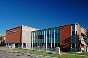 Front of Malheur county courthouse shown with grassy area in front and parking lot.