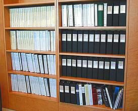 Wooden bookshelves holding books and binders.