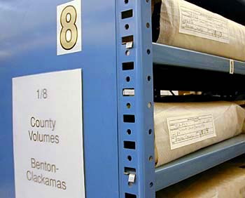 The end of a metal shelf with the number 8 and a sign reading "1/8 County Volumes Benton-Clackamas."