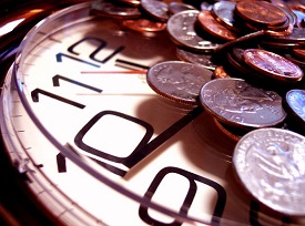 Face of a clock showing the 12, 11, 10, and 9 side. The remainder of the clock is covered by quarters, pennies and other change.