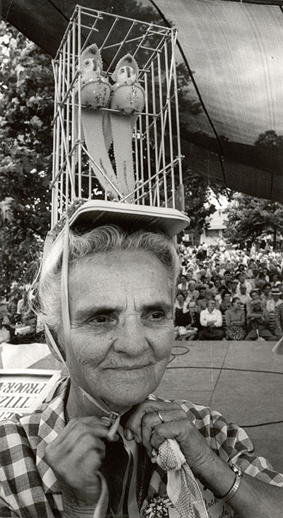 A woman wears a bird hat