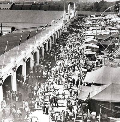 Crowds of people walk by food booths