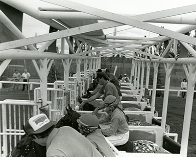 Jockeys sit on horses at the gate in a horse race