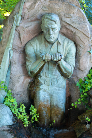 soldier kneeling at stream for water