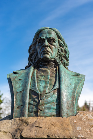 Bronze bust of John McLoughlin set in a large rock.