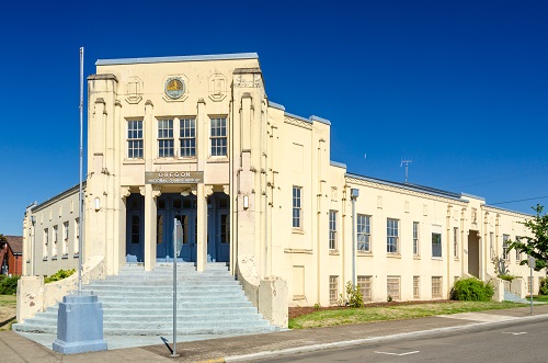 Art Deco building constructed in 1931. Two-story cast-in-place concrete structure with steps at angle to the corner of block.