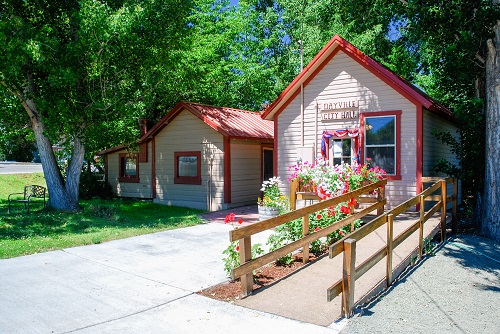 Dayville City Hall looks like a single family dwelling. There is a wheelchair ramp on the right & paved driveway.