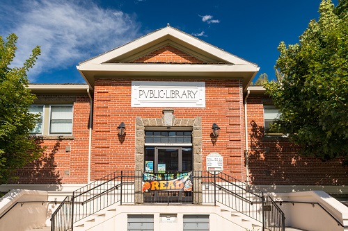 Brick building with stone foundation in classical revival architectural style.