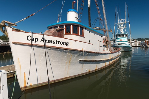 A boat on the water with the name "Cap Armstrong" printed on the side.