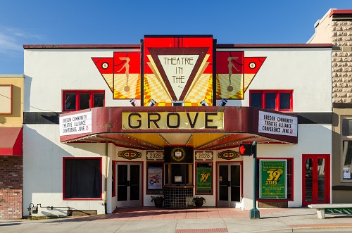 Theatre in the Grove entry has 2 sets of double doors, 1 on each side of the ticket booth in the center.