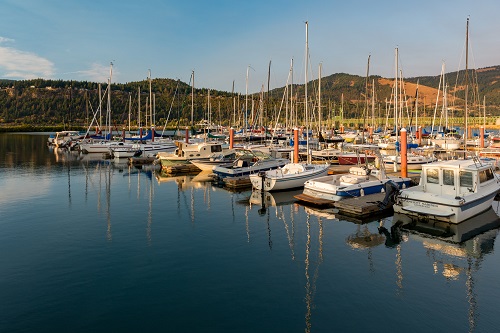 Approximately 30 personal boats docked at a marina.