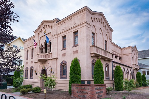 Front of the Masonic Lodge shows the lancet arch entry with a keystone made of the sqare and compass insignia for Freemasonry. 