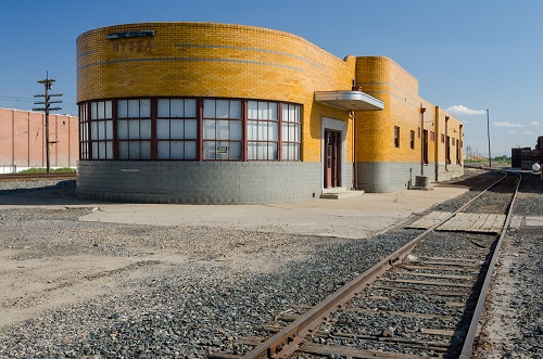 The building was probably built in the 1930’s or 40’s in the Streamline Moderne style. Rounded walls. Train track on right.