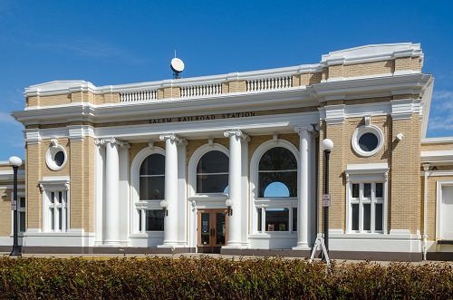 Beaux-Arts-style structure constructed of masonry. Passengers enter through colossal columns encompassed by large Roman arched windows. West entrance is 4 pilaster colonnades, with the four columns directly in front & a 3-arched recessed entranceway & double doors at the center. 