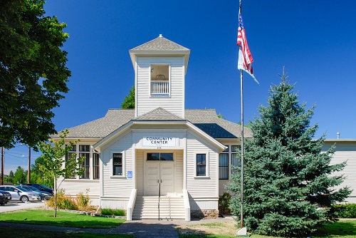 Single-story building with 2-story tower at front. Double doors for front door with steps leading up to elevated entrance.