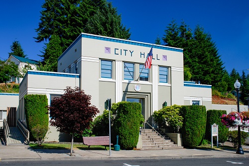 Single story building with 1st floor raised above the sidewalk a few feet. Stairs lead up from sidewalk to double font doors.