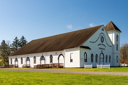 Timber frame tabernacle 110 by 160 feet built in 1891. 1 tower to side of front door. Stained glass windows on all sides.