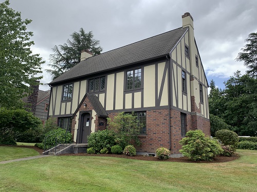 Three story building with brick covering first story outside.