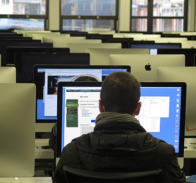 Student sitting at computer with MyVote on screen.